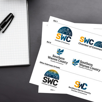 papers on a table with the drafted logos of the Southern Warren County Chamber redesign